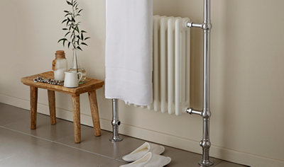 White column towel radiator with chrome pipework on both sides.