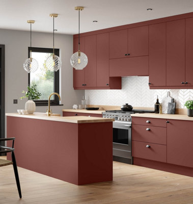 A red kitchen with an island, light wooden worktops and wooden flooring.