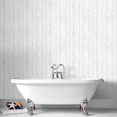 Traditional style claw foot bath installed in front of a grey panelled bathroom wall.