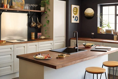 A rustic cream kitchen with dark wood worktops and a kitchen island.
