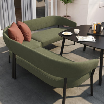 Scandi, green outdoor sofa an sleek black table on a terrace.