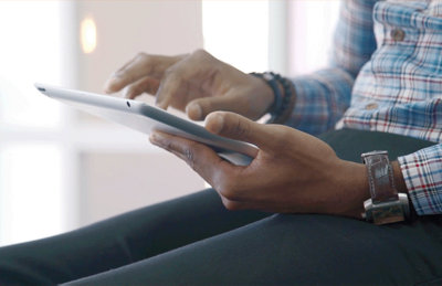 Person hands on an ipad, touching the screen.