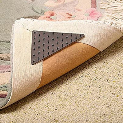 https://media.diy.com/is/image/KingfisherDigital/set-of-4-triangular-rug-grippers-anti-slip-universal-strong-gripping-spikes-for-rugs-mats-and-runners~5053335609733_02c_MP?$MOB_PREV$&$width=618&$height=618