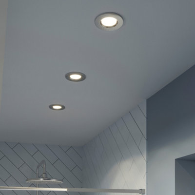 Three spotlights installed above a shower enclosure to brighten the space.