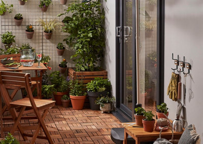 A small garden deck with a foldable wooden garden table and two folding chairs.