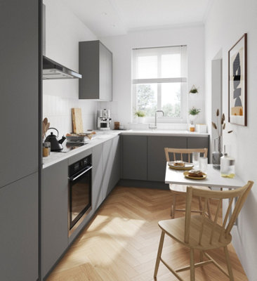 Small kitchen with matt grey cabinets, white walls, white splashback, and wooden flooring.