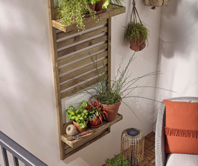 Wooden vertical slat trellis with built-in shelves mounted on an external wall.