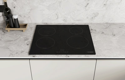 Black ceramic hob set into a marble-effect worktop.