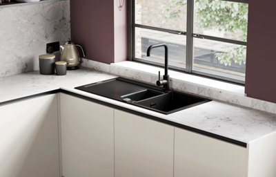 Black inset sink and tap set into a marble-effect worktop.