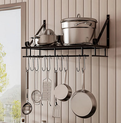 A wall mounted kitchen pot rack with utensils hanging from hooks underneath.