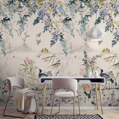 A charming room with a white table, two pale pink chairs and a watercolour effect wall mural of a lake scene as a beautiful feature wall.