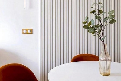 White dining room with white acoustic panel behind dining table.