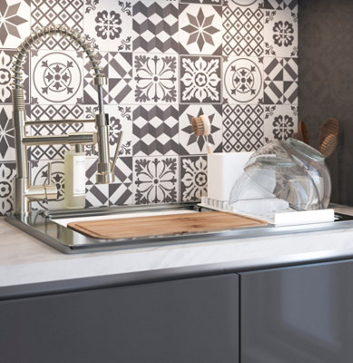 White and grey patterned mosaic tile splashback in a grey kitchen.