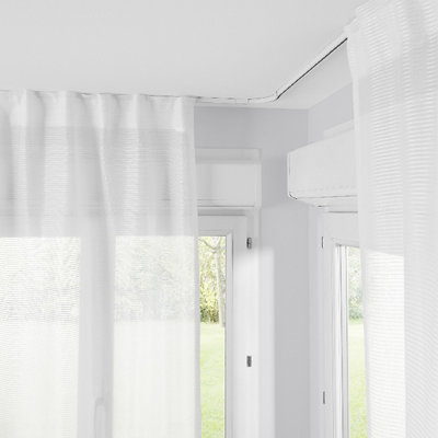 Curtain track bent at a right angle around the corner of a bay window.