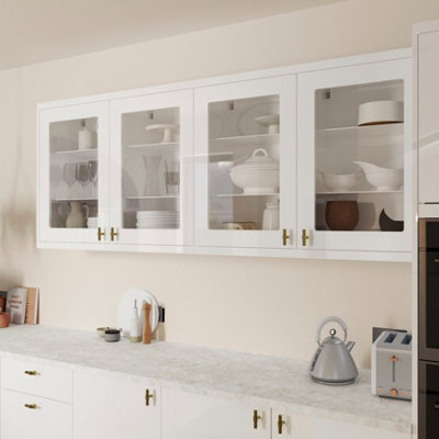 A white kitchen with wall mounted cabinets with glass doors.