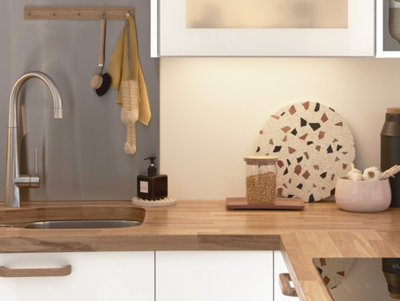 A white kitchen with wooden worktops and kitchen accessories.