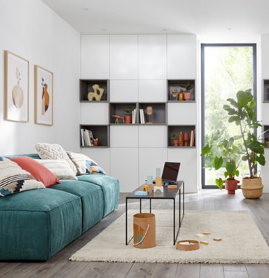 A white living room with wall height modular storage units.