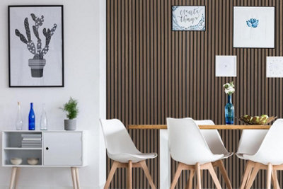 Thin dark wood panelled feature wall behind a light wooden dining table with white dining chairs.